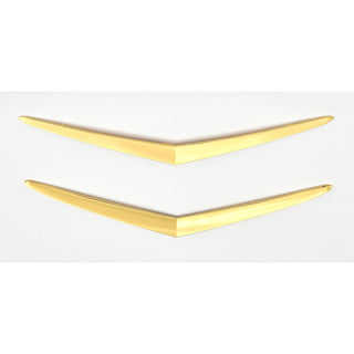 Two gold V-shaped objects on a white background. 1957 Chevy Hood and Trunk Vee Set, Gold.
