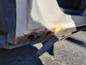 Rust and damage on a vehicle's side panel